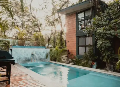 a swimming pool in front of a house at Blue 2BR 2BA 10 Min Beach Walk in Nosara