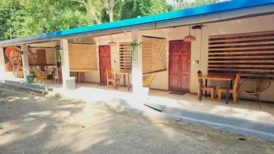 a porch of a house with a table and chairs at Santa Toro, private rooms close to the beach in Santa Teresa Beach
