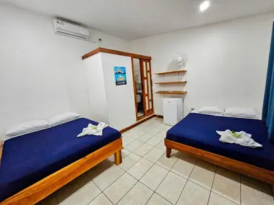a bedroom with two beds in a room at Santa Toro, private rooms close to the beach in Santa Teresa Beach