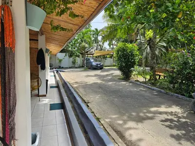 a house with a driveway with a car parked on the street at Santa Toro, private rooms close to the beach in Santa Teresa Beach