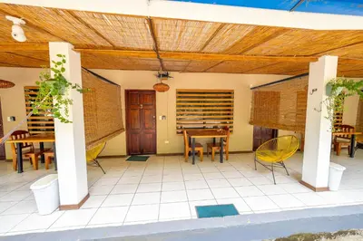 a patio with a table and chairs and a wooden ceiling at Santa Toro, private rooms close to the beach in Santa Teresa Beach
