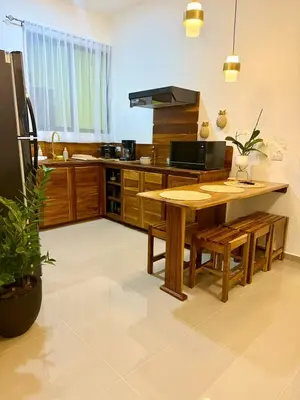 a kitchen with a wooden table and a counter top at Casa Sol in Naranjito