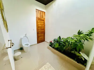 a bathroom with a toilet and some plants in it at Casa Sol in Naranjito