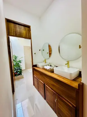 a bathroom with two sinks and two mirrors at Casa Sol in Naranjito