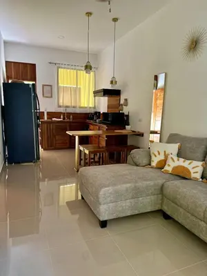 a living room with a couch and a kitchen at Casa Sol in Naranjito