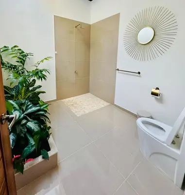 a bathroom with a toilet and a plant at Casa Sol in Naranjito