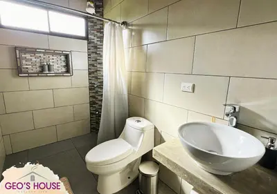 a bathroom with a white toilet and a sink at Geo'S House & Volcan View in Fortuna