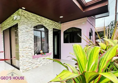 a home with a pink house with plants at Geo'S House & Volcan View in Fortuna