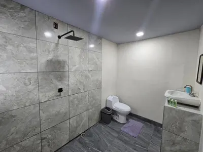 a bathroom with a shower and a toilet and a sink at Apartamento Las Tecas in Quepos