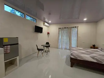 a bedroom with a bed and a table and chairs at Apartamento Las Tecas in Quepos