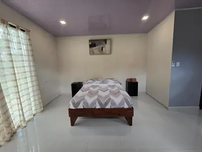 a bedroom with a bed in the corner of a room at Apartamento Las Tecas in Quepos