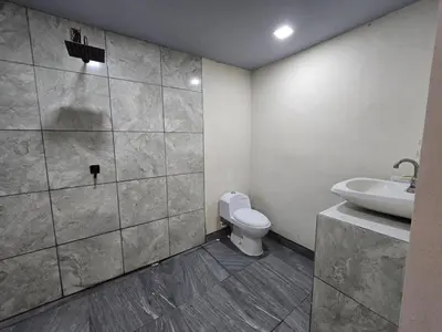a bathroom with a white toilet and a sink at Apartamento Las Tecas in Quepos