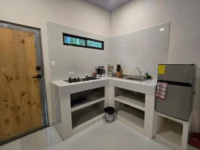 a white kitchen with a sink and a window at Apartamento Las Tecas in Quepos