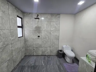 a bathroom with a toilet and a sink and a window at Apartamento Las Tecas in Quepos