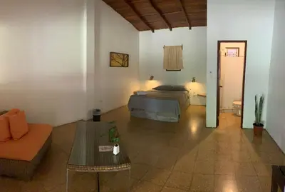 a bedroom with a bed and a couch and a table at Hotel Monte del Mago in Carrillos