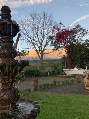 a fountain in a yard with a boat in the background at Hotel Monte del Mago in Carrillos