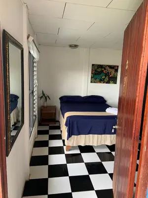 a bedroom with a bed and a black and white checkered floor at Hotel Monte del Mago in Carrillos