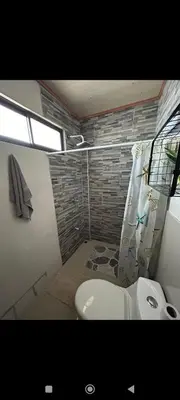 a bathroom with a white toilet and a shower at Wileri in Tapantí