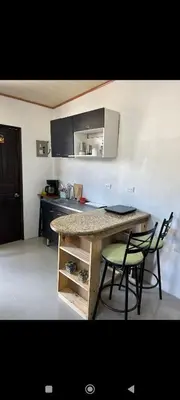 a kitchen with a table and two chairs and a counter at Wileri in Tapantí