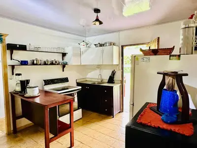 a small kitchen with a table and a refrigerator at Casa de Campo en Rivas de Pérez Zeledon in Rivas