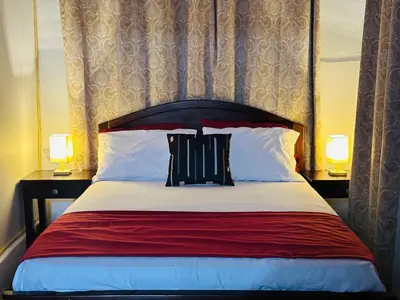 a bedroom with a large bed with two lamps at Casa de Campo en Rivas de Pérez Zeledon in Rivas