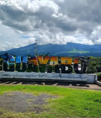 a bench with graffiti on it in a park at Cabina Antigua Plaza in Tapantí