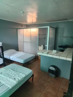 a room with two beds and a mirror at Cabina Antigua Plaza in Tapantí