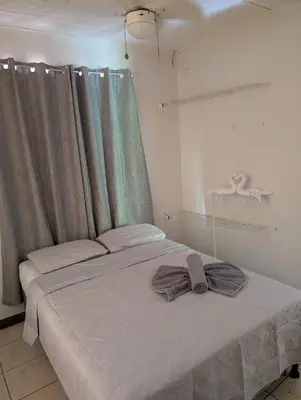 a bedroom with a bed with two towels on it at Pura Vida Paz y Amor in Quepos