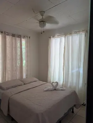 a bedroom with a bed with a bow on it at Pura Vida Paz y Amor in Quepos