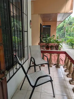 a chair and a table on a balcony at Pura Vida Paz y Amor in Quepos