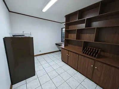 an empty room with wooden shelves and a kitchen at House in Rohrmoser near the National Stadium of CR in San José
