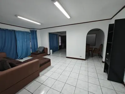 a living room with a couch and a tv at House in Rohrmoser near the National Stadium of CR in San José