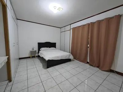 a bedroom with a bed and curtains in it at House in Rohrmoser near the National Stadium of CR in San José