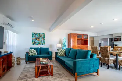 a living room with two blue couches and a table at Viva Jaco II in Jacó