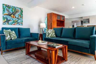 a living room with two blue couches and a coffee table at Viva Jaco II in Jacó