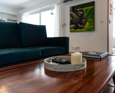 a living room with a couch and a table with a candle at Viva Jaco II in Jacó