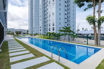 a swimming pool in a building with tall buildings at Viva Jaco in Jacó