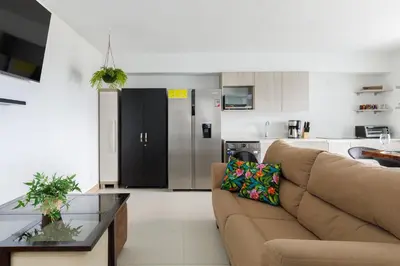a living room with a couch and a kitchen at Viva Jaco in Jacó