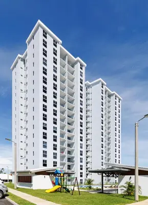 a large white building with a playground in front of it at Viva Jaco in Jacó