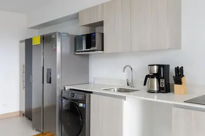 a kitchen with a refrigerator and a washing machine at Viva Jaco in Jacó