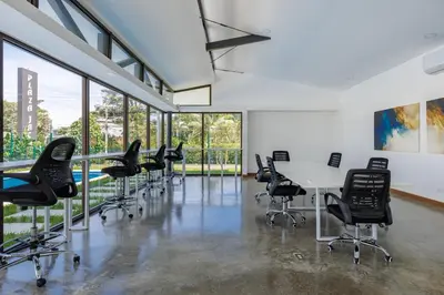 an office with chairs and tables in a room with windows at Viva Jaco in Jacó