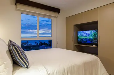 a bedroom with a large bed and a large window at Viva Jaco in Jacó