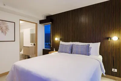a bedroom with a large white bed and a mirror at Viva Jaco in Jacó