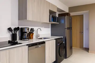 a kitchen with a stainless steel refrigerator and a dishwasher at Viva Jaco in Jacó