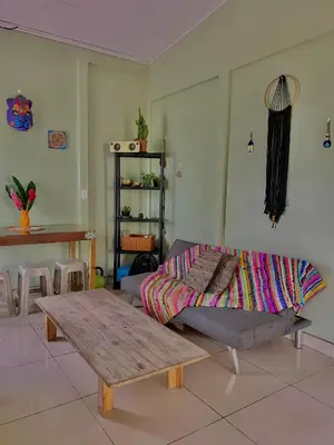 a living room with a bed and a wooden table at Casa mariposa in Uvita