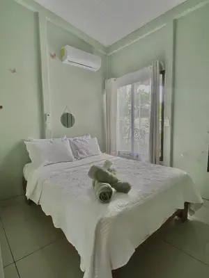 a teddy bear laying on a bed in a bedroom at Casa mariposa in Uvita