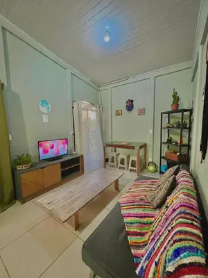 a living room with a couch and a tv at Casa mariposa in Uvita