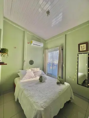 a green bedroom with a bed with two green walls at Casa mariposa in Uvita