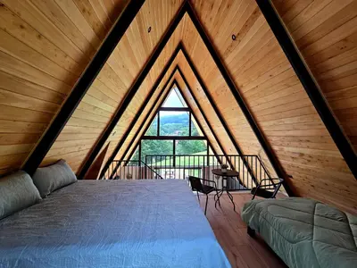a bedroom with a bed and a large window at Monteluna Fraijanes in Poasito