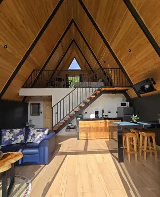 a living room with a blue couch and a staircase at Monteluna Fraijanes in Poasito